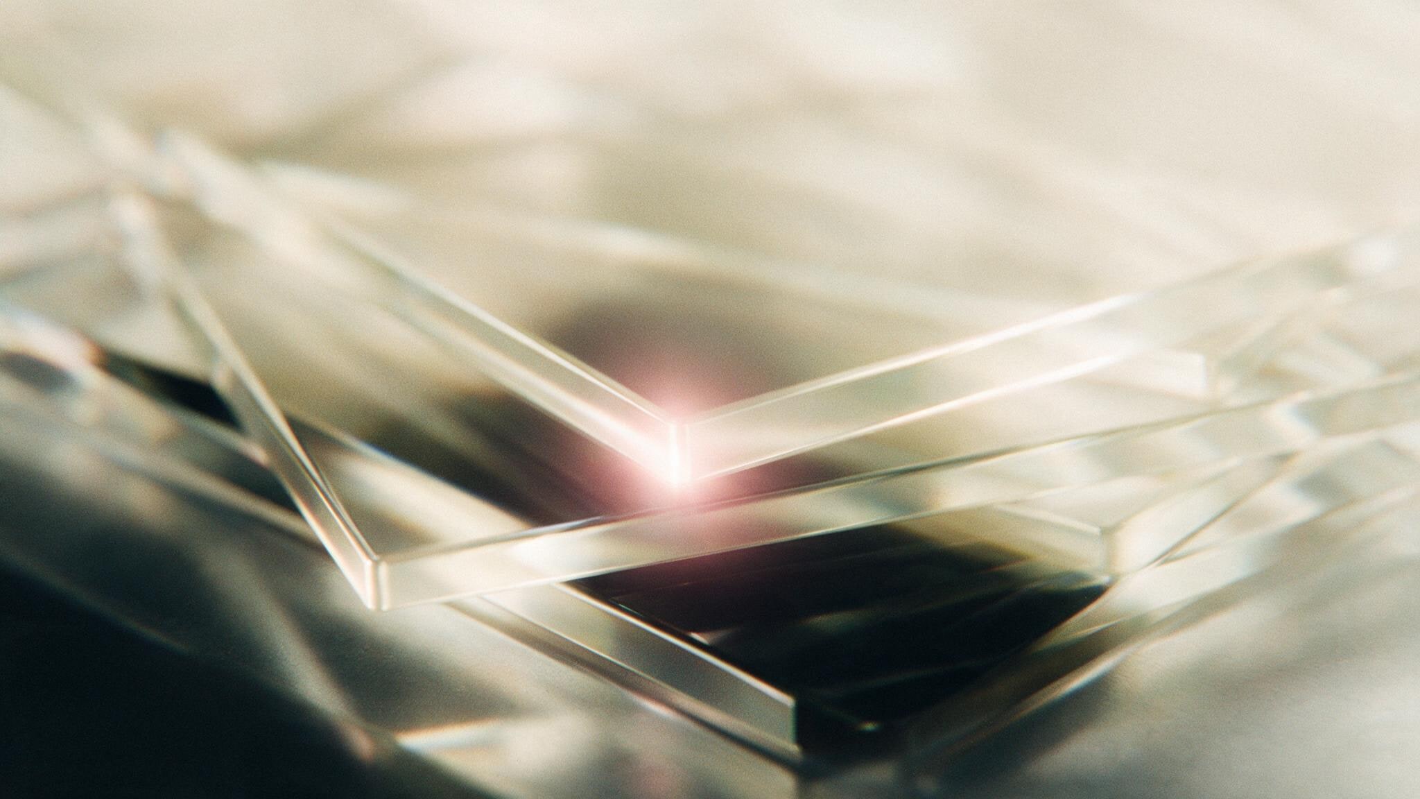 Stacked slabs of clear glass, edge lit so a thin line of refracted light runs along each bevel.
